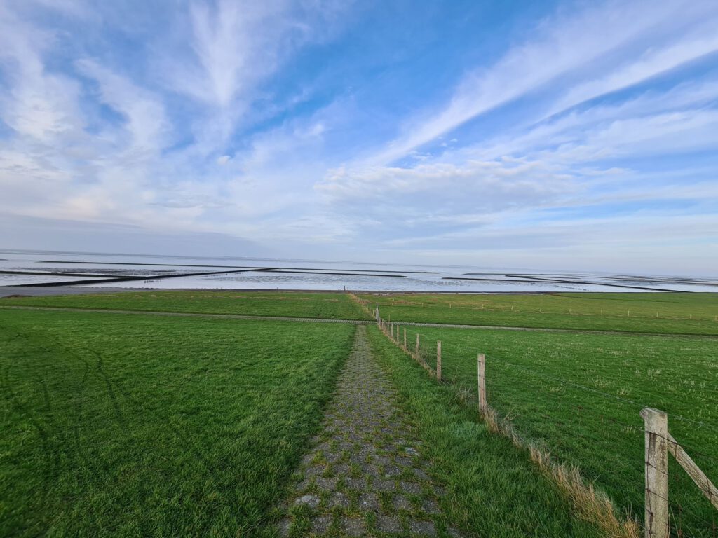 Weitblick vom Deich herunter auf das Meer