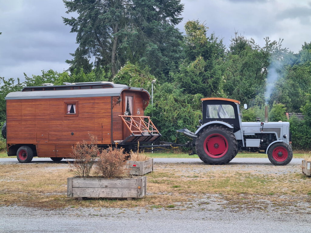 Alter Trecker mit selbst ausgebautem Wohnanhänger auf dem Stellplatz in Höxter.